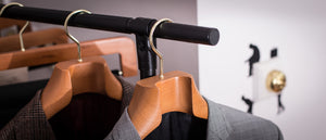 Wooden hangers with a suit jacket on a rack against a blurred background