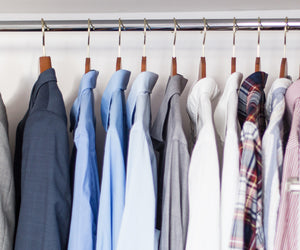 Row of shirts on hangers against a white wall