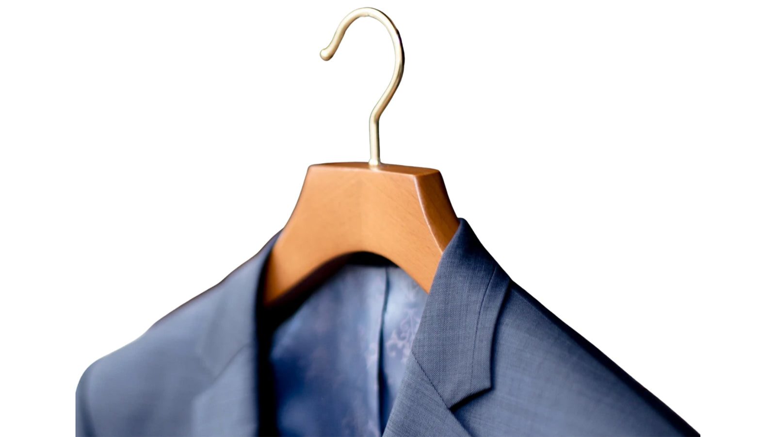 Blue shirt on a wooden hanger against a white background